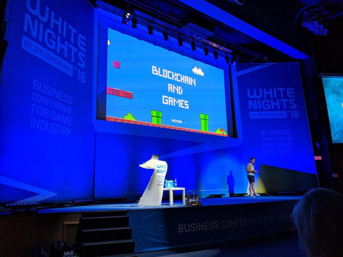 Me standing on stage at WHITE NIGHTS delivering a talk about games on Blockchain